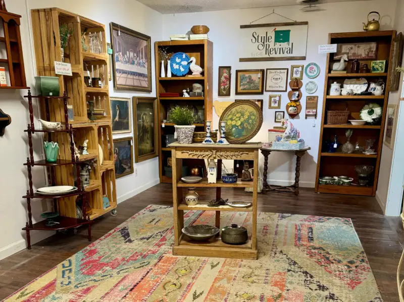 A wood kitchen cart and shelves of pottery in the booth